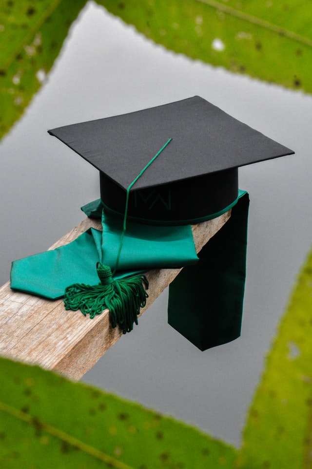 graduation cap on green tie on table